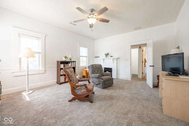 living room featuring baseboards, a ceiling fan, light colored carpet, and visible vents