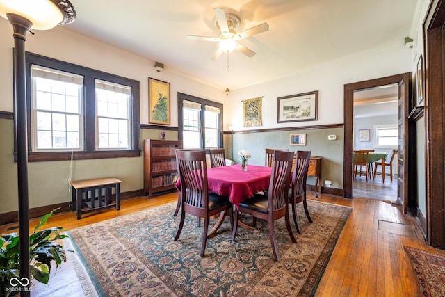 dining room with a ceiling fan, baseboards, ornamental molding, and hardwood / wood-style floors