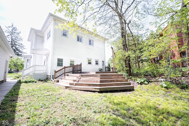 rear view of house with a wooden deck and a yard