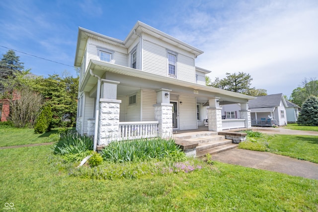 view of front of property featuring covered porch and a front lawn
