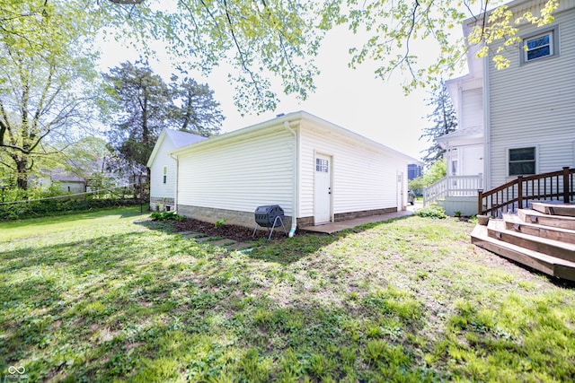 exterior space with a lawn, a wooden deck, and fence