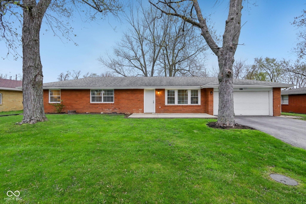 ranch-style home with driveway, a front lawn, brick siding, and a garage
