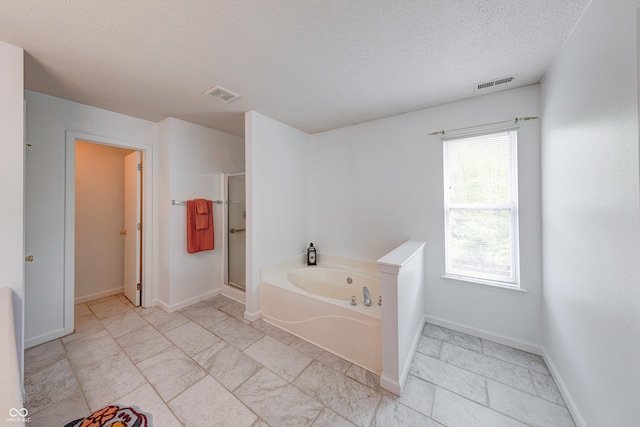 5989 Ashmore Ln, Carmel, IN 46033 - bathroom featuring a textured ceiling, a bath, a shower stall, and baseboards