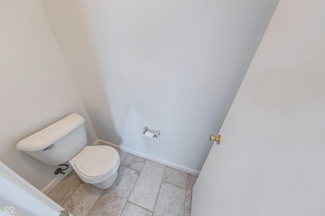 5989 Ashmore Ln, Carmel, IN 46033 - bathroom featuring toilet, marble look tiles, and baseboards