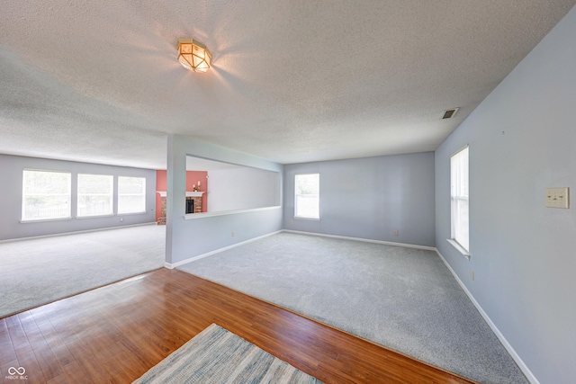 5989 Ashmore Ln, Carmel, IN 46033 - carpeted spare room with a textured ceiling, wood finished floors, and baseboards