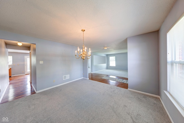 5989 Ashmore Ln, Carmel, IN 46033 - unfurnished dining area with carpet floors, a chandelier, baseboards, and a textured ceiling