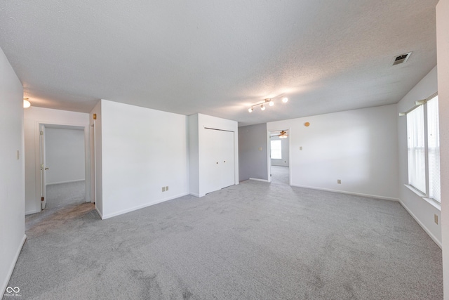 5989 Ashmore Ln, Carmel, IN 46033 - spare room featuring a ceiling fan, light carpet, baseboards, and a textured ceiling