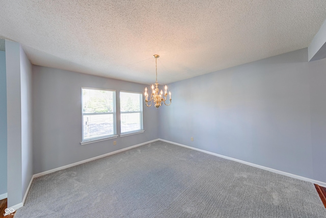 5989 Ashmore Ln, Carmel, IN 46033 - unfurnished room featuring a chandelier, dark carpet, baseboards, and a textured ceiling