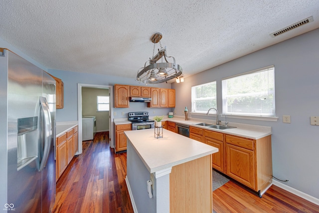 5989 Ashmore Ln, Carmel, IN 46033 - kitchen featuring stainless steel appliances, a sink, under cabinet range hood, light countertops, and wood finished floors