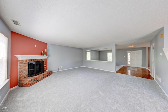 5989 Ashmore Ln, Carmel, IN 46033 - unfurnished living room with carpet floors, a brick fireplace, baseboards, and a textured ceiling