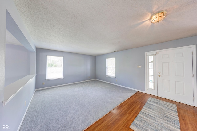 5989 Ashmore Ln, Carmel, IN 46033 - entryway with baseboards, a textured ceiling, wood finished floors, and carpet flooring