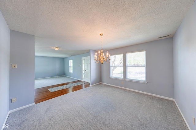 5989 Ashmore Ln, Carmel, IN 46033 - carpeted empty room with a chandelier, baseboards, and a textured ceiling