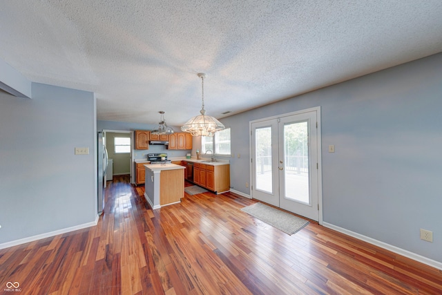 5989 Ashmore Ln, Carmel, IN 46033 - kitchen with appliances with stainless steel finishes, light countertops, french doors, a textured ceiling, and a chandelier
