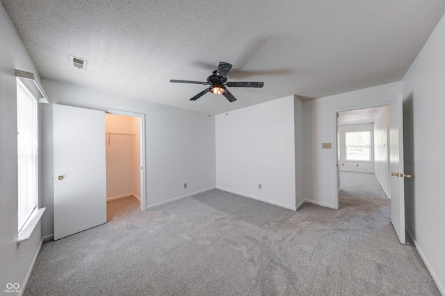 5989 Ashmore Ln, Carmel, IN 46033 - unfurnished bedroom with carpet floors, a spacious closet, a textured ceiling, a ceiling fan, and baseboards