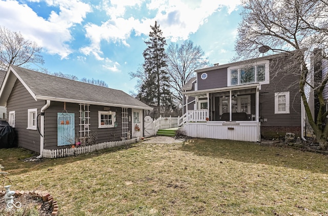 rear view of property with a yard, fence, and a sunroom