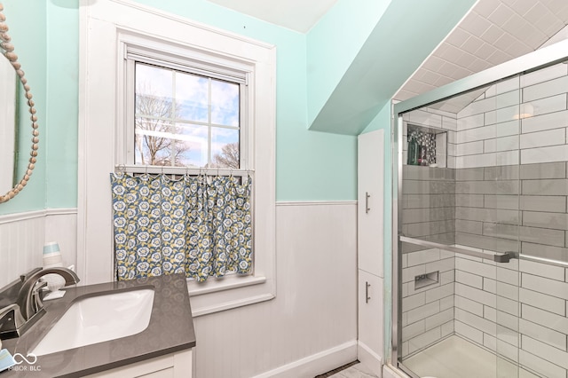 full bath with vanity, wainscoting, and a stall shower
