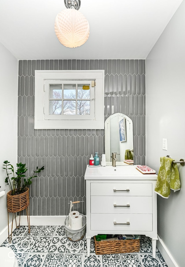 bathroom featuring tile patterned flooring, baseboards, and vanity