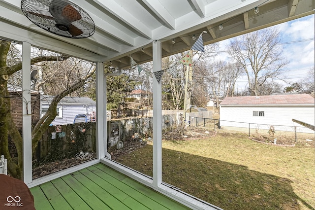 unfurnished sunroom featuring ceiling fan and beamed ceiling