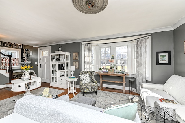 living room with crown molding, baseboards, a healthy amount of sunlight, and wood finished floors
