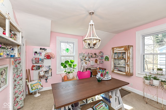 carpeted dining room with baseboards, a notable chandelier, vaulted ceiling, and a healthy amount of sunlight