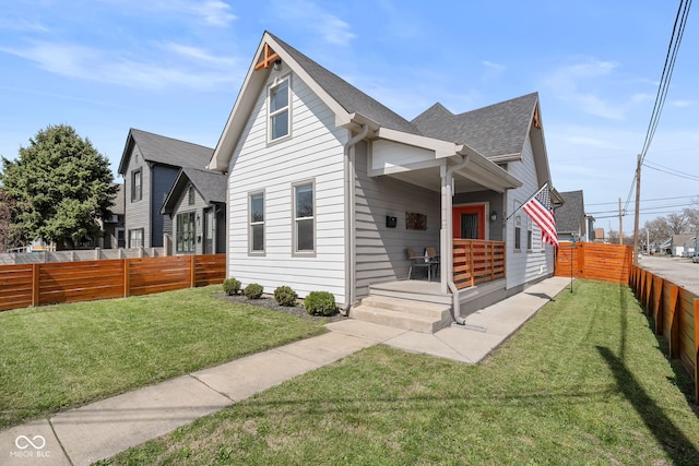 358 Terrace Ave, Indianapolis, IN 46225 - view of front facade with a shingled roof, a front yard, a porch, and fence private yard