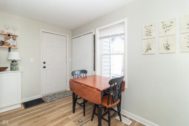 dining area with baseboards, visible vents, and light wood-style floors