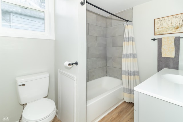 bathroom featuring toilet, shower / tub combo, wood finished floors, and vanity