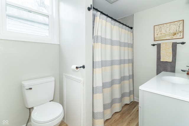 full bathroom featuring a shower with shower curtain, toilet, vanity, wood finished floors, and baseboards