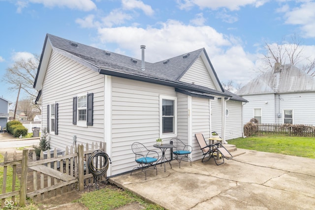 back of house with a patio, fence, and roof with shingles