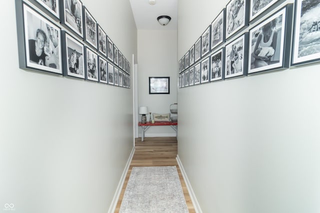 hall featuring baseboards and wood finished floors