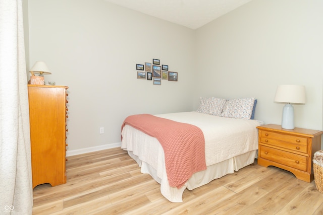 bedroom with baseboards and wood finished floors