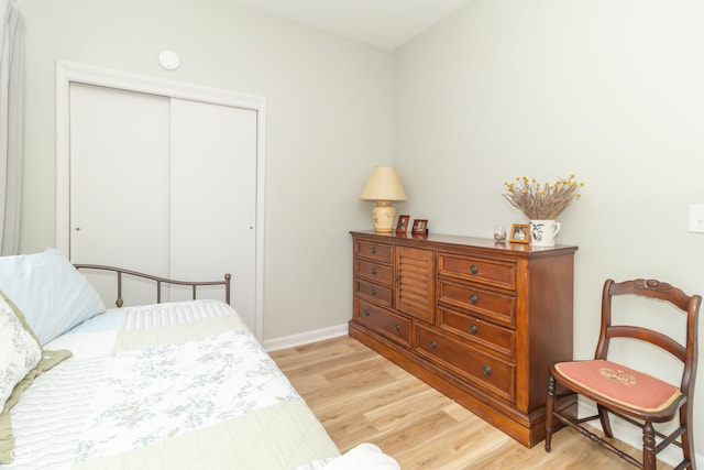 bedroom featuring baseboards, a closet, and light wood-style floors