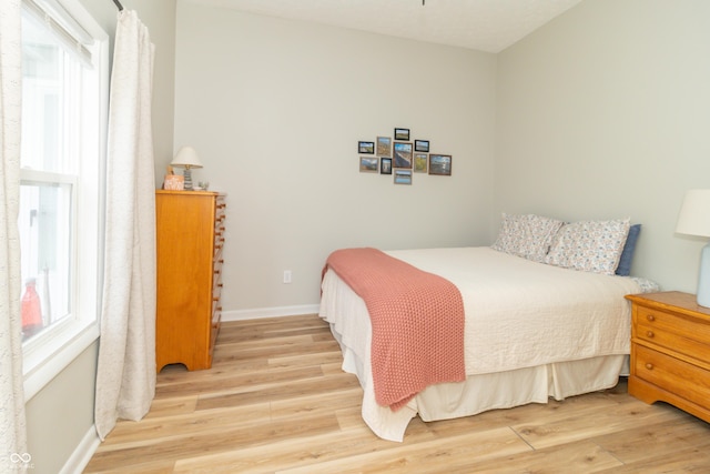 bedroom featuring light wood-style flooring and baseboards