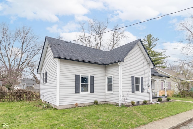 view of side of property with a lawn and a shingled roof
