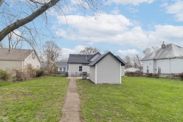 rear view of property featuring fence and a yard