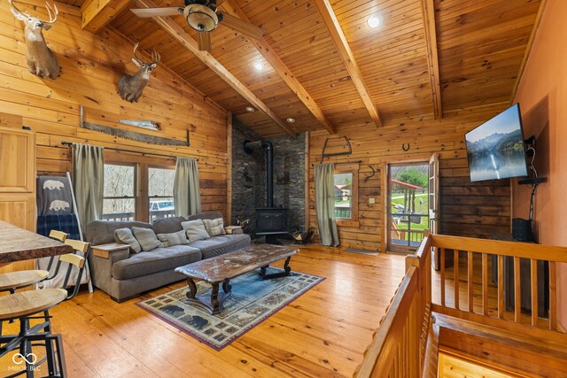 6351 Dixon Rd, Columbus, IN 47201 - living room featuring a wood stove, light wood-style floors, wood ceiling, beamed ceiling, and wood walls