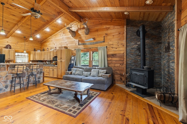 6351 Dixon Rd, Columbus, IN 47201 - living area with light wood-style floors, a wood stove, beamed ceiling, a ceiling fan, and wood ceiling