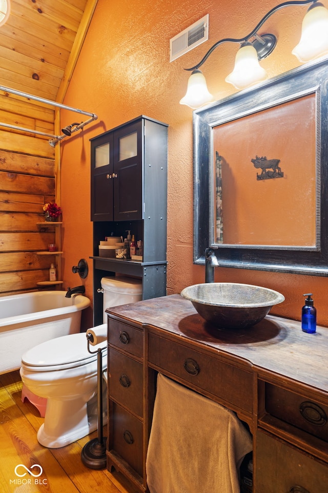 6351 Dixon Rd, Columbus, IN 47201 - full bathroom featuring vanity, toilet, visible vents, lofted ceiling, and wood-type flooring