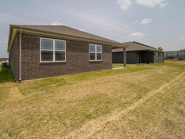 915 Saddlebrook Farms Blvd, Whiteland, IN 46184 - rear view of house with brick siding, a lawn, and roof with shingles
