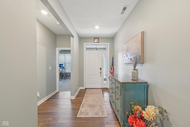 entryway with baseboards, dark wood-style flooring, visible vents, and recessed lighting