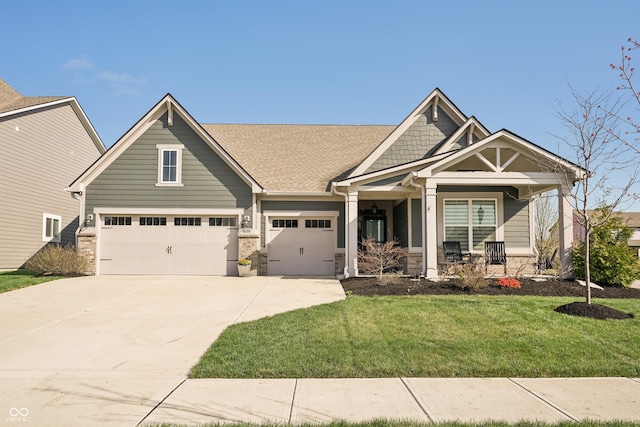 craftsman inspired home featuring driveway, stone siding, a porch, and a front yard