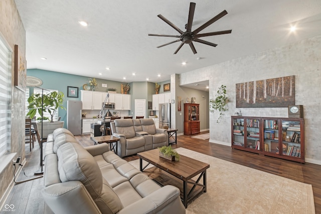 living area featuring baseboards, wood finished floors, ceiling fan, and recessed lighting