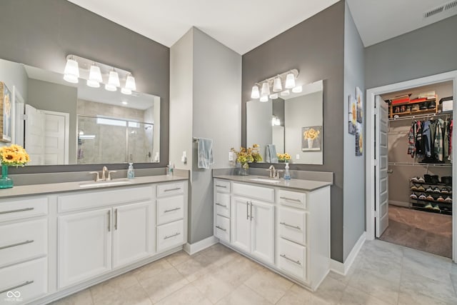 bathroom featuring a sink, visible vents, a stall shower, and two vanities