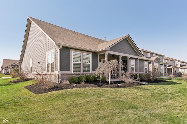 exterior space with brick siding, a shingled roof, and a front lawn