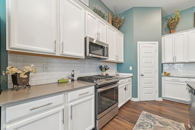 kitchen featuring dark wood-style floors, white cabinets, tasteful backsplash, and appliances with stainless steel finishes