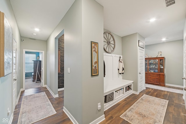 hall with baseboards, visible vents, recessed lighting, and dark wood-style flooring