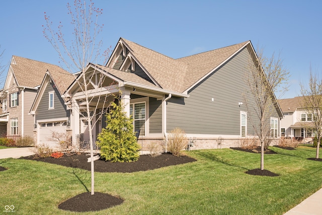 craftsman house featuring a front yard, concrete driveway, a garage, and a shingled roof