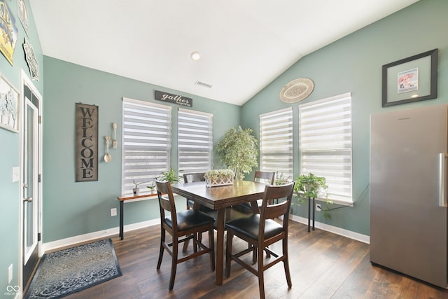 dining area featuring dark wood-type flooring, lofted ceiling, visible vents, and baseboards