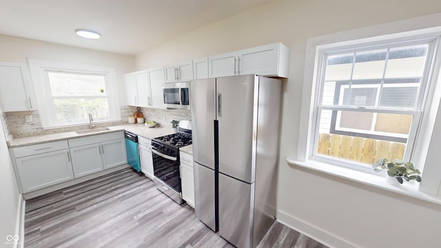 926 N Dearborn St, Indianapolis, IN 46201 - kitchen with stainless steel appliances, backsplash, plenty of natural light, and light wood-style floors
