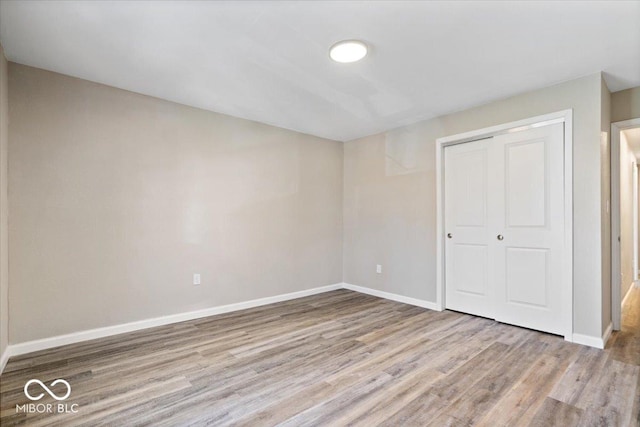 243 N Tacoma Ave, Indianapolis, IN 46201 - unfurnished bedroom with wood finished floors, a closet, and baseboards